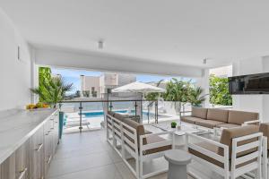 cocina y sala de estar con vistas a la piscina en Olymp Luxury Family House, en Paphos