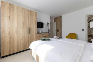 a bedroom with a large white bed and wooden cabinets at Villa Petrina by Istrialux in Sveti Petar u Šumi +29 photos