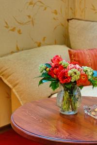 a vase filled with flowers sitting on a table at Capitol Hotel in Varna City