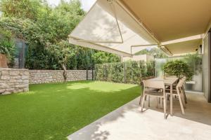 a garden with a table and a green lawn at Villa Callista Mentone in Menton