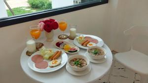 un tavolo con piatti di cibo e bicchieri di succo d'arancia di วีรพัชนารา a Ban Musoe Altre 54 foto