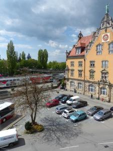 een groep auto's geparkeerd op een parkeerplaats voor een gebouw bij Inselhostel in Lindau