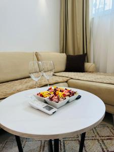 ein weißer Tisch mit einem Teller mit Essen und zwei Weingläsern in der Unterkunft The pearl residence Sarajevo - Bascarsi - Walk everywhere in Sarajevo