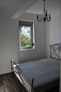 a bedroom with a bed and a window at Old Town View Apartment in Budva