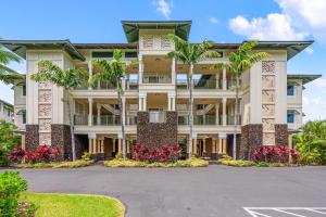 a building with palm trees in front of it at Big Island Kolea 14H by Coldwell Banker Island Vacations in Waikoloa
