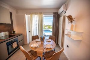 Una cocina y un comedor con mesa y sillas. en Lotus Apartment 140 in Odyssey Pool & Spa-parking, en Mamaia