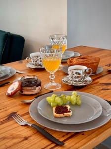 einen Tisch mit einem Teller mit Lebensmitteln und Gläsern Orangensaft in der Unterkunft Peroba Ville Residence AP completo in Maragogi