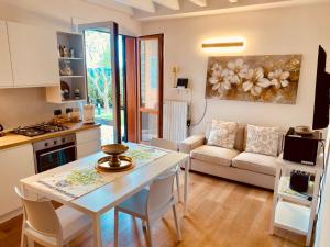 een keuken en woonkamer met een tafel en een bank bij Piccolo Sogno in Desenzano del Garda