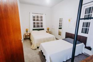 ein Schlafzimmer mit zwei Betten und zwei Fenstern in der Unterkunft Casa c/ Piscina e Área Gourmet Perto da Praia in São Sebastião + 12 Fotos