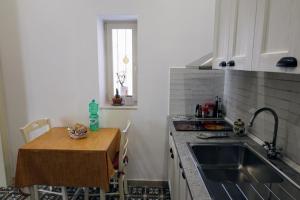 a kitchen with a sink and a small table with a tableablish at a Casa di Maria in Vieste