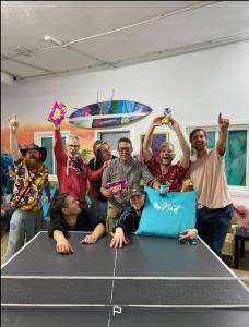 a group of people standing around a table with their hands in the air at Medano Nest Hostel in El Médano