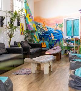 a living room with couches and a colorful mural at Medano Nest Hostel in El Médano