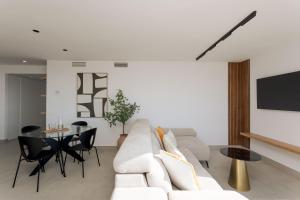 a living room with a white couch and a table at Apartamento Exclusivo Frente al Mar in Aguadulce