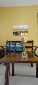 a bag sitting on a wooden table with a vase of flowers at Affordable Whole House Rent Transient in Butuan