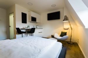 a bedroom with a white bed and a table and chairs at Apartmenthaus Königsallee in Bayreuth