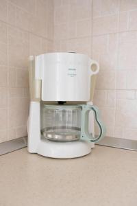 ギシオにあるMelina's apartmentの白いコーヒーメーカー(カウンターの上に座る)