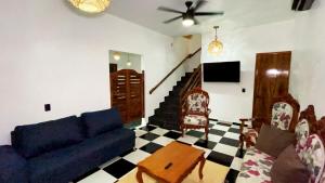 a living room with a blue couch and chairs at Casa Jabalí Ecocchic in Tulum