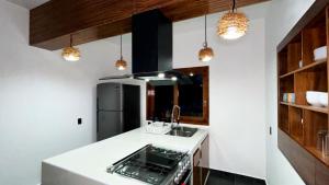 a kitchen with a sink and a refrigerator at Casa Jabalí Ecocchic in Tulum