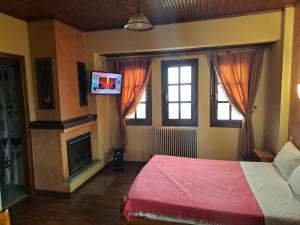 a bedroom with a bed and a flat screen tv at Olga Studios in Tsagarada