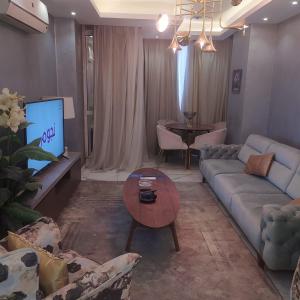 un salon avec un canapé et une télévision dans l'établissement شقه فاخره لايجار, au Caire