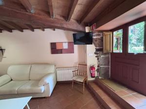 a living room with a couch and a tv at Couso Relax in Sarreaus
