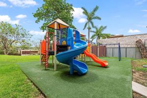 a playground with a blue and red slide at Ocean Views, Rooftop Terrace & Resort Pools in Tamarindo