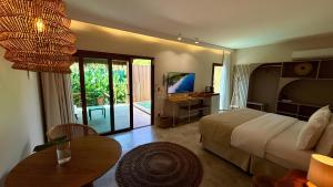 a bedroom with a bed and a table and a television at Dolphin Hotel in Fernando de Noronha