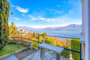 een bank op een balkon met uitzicht op het water bij Appartamento Valentina in Oggebio