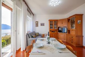 een eetkamer met een tafel en een bank bij Appartamento Valentina in Oggebio