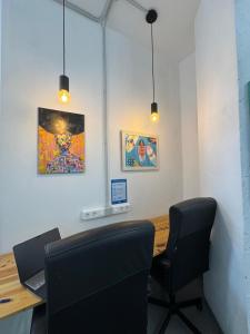 a room with a desk with two chairs and a laptop at Medano Nest Hostel in El Médano