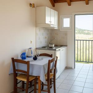 a kitchen with a table with two chairs and a table with wine glasses at Blue Lake Holiday Homes - Keri Summer Escape in Keri