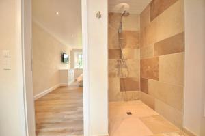 a bathroom with a walk in shower next to a hallway at Doppelhaushälfte SPO-Stern in Böhl +20 photos