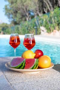 a plate of fruit and two glasses of wine at Villa Kiki - Klodge in Costa Corallina