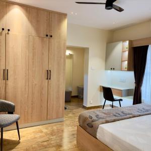 a bedroom with a bed and a large wooden cabinet at Zoe Villa in Trivandrum