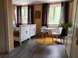 a small room with a bed and a table and chairs at ByTheLake in Konstantinovy Lázně
