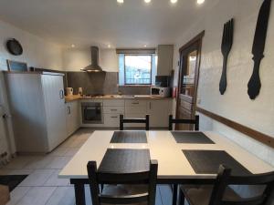 a kitchen with a table and some utensils on the wall at Au Vieux Fenil in Rendeux +13 photos