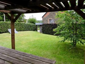 a view of a yard with a wooden bench at Au Vieux Fenil in Rendeux