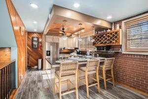 a kitchen with a island with chairs and a brick wall at The Townline House in Union Pier