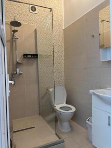 a bathroom with a toilet and a glass shower at La Cer in Constanţa
