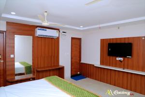a room with a bed and a tv on a wall at AA Residency in Tirupati
