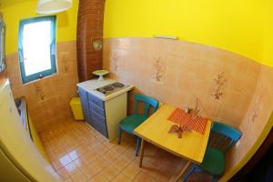 a small kitchen with a table and chairs and yellow walls at Dalmatian rustic house in Petrcane