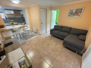 a living room with a couch and a kitchen at Veronica nyaralóház in Zamárdi