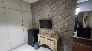 a room with a stone wall with a television on it at Karachi cozy corner in Dargai