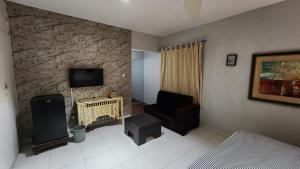 a living room with a couch and a tv and a chair at Karachi cozy corner in Dargai