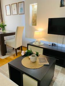 a living room with a coffee table with a television at Beli Apartman u Zlatiborskim konacima Bele vode bb in Zlatibor