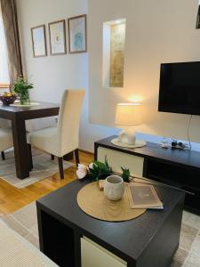 a living room with a coffee table with a desk at Beli Apartman u Zlatiborskim konacima Bele vode bb in Zlatibor