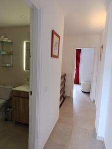 a hallway of a bathroom with a sink and a mirror at Vox Maris by Wyndham Costa del Sol in Fuengirola