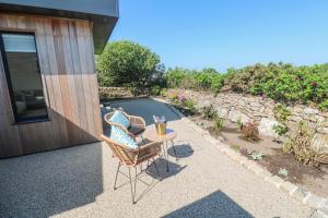 a patio with two chairs and a table next to a pool at Little Victory in Penzance