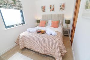 a bedroom with a bed with a bowl of fruit on it at Little Victory in Penzance