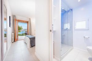 a white bathroom with a shower and a toilet at Ull de Bou in Port de Pollensa +9 photos